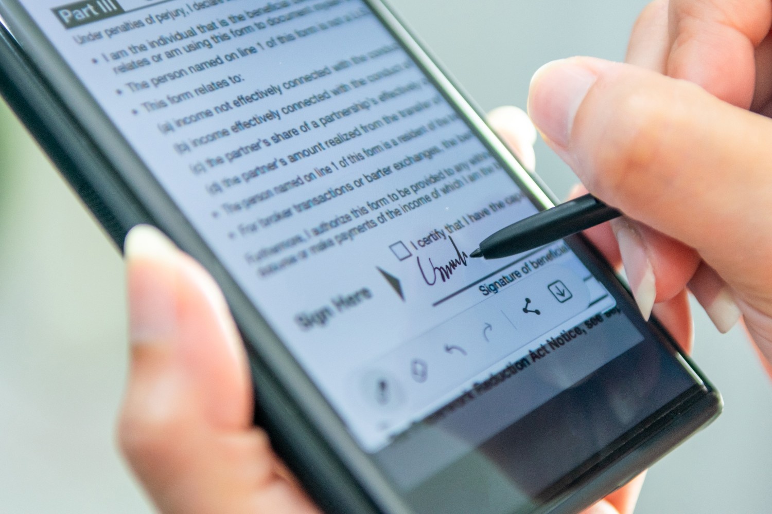 User signing a digital document on a smartphone using an app to sign documents, demonstrating a free app for electronic signature with secure mobile approval.