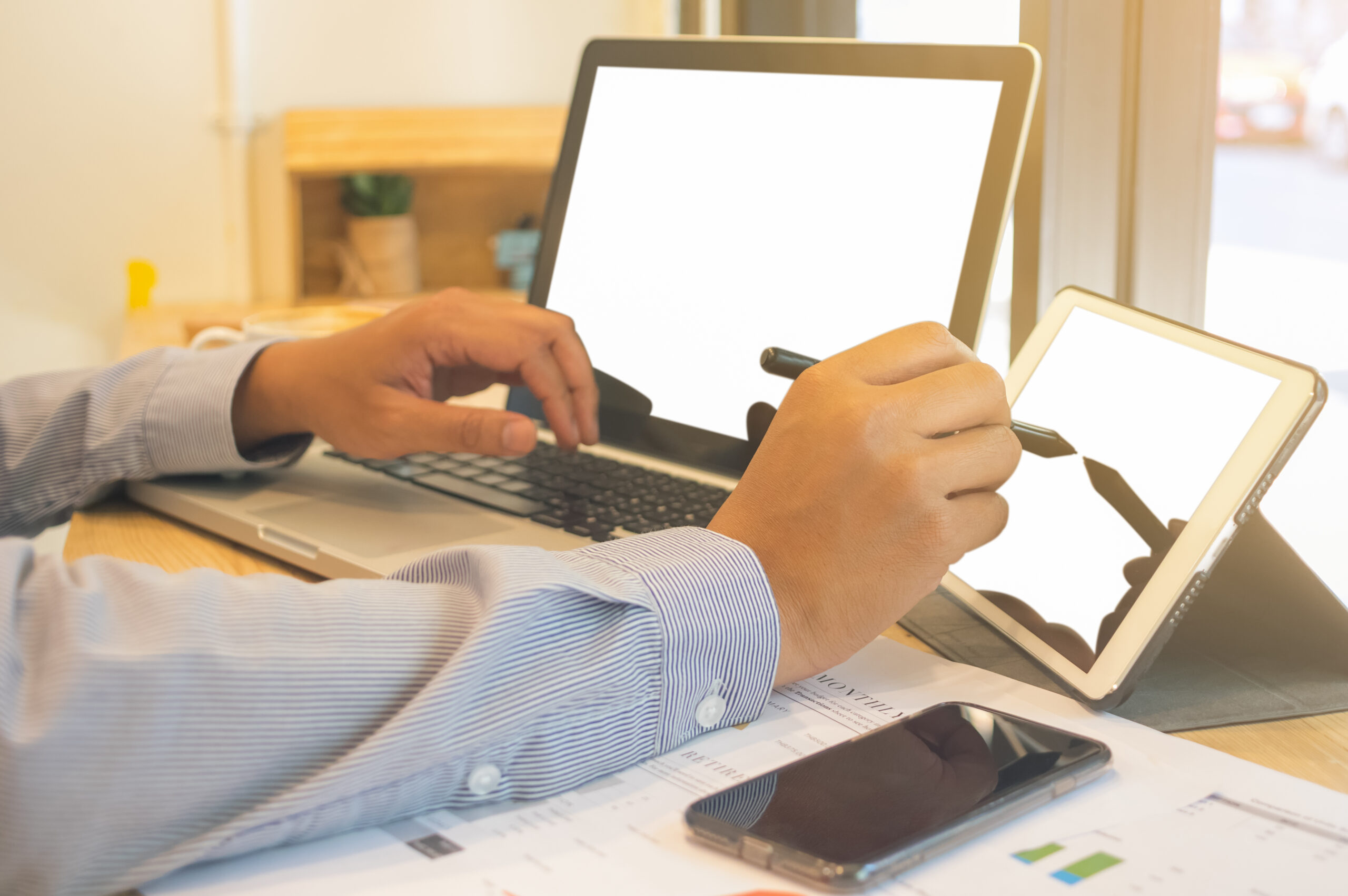 Professional using eSignature platforms on tablet and laptop to sign documents digitally with a free electronic signature solution.