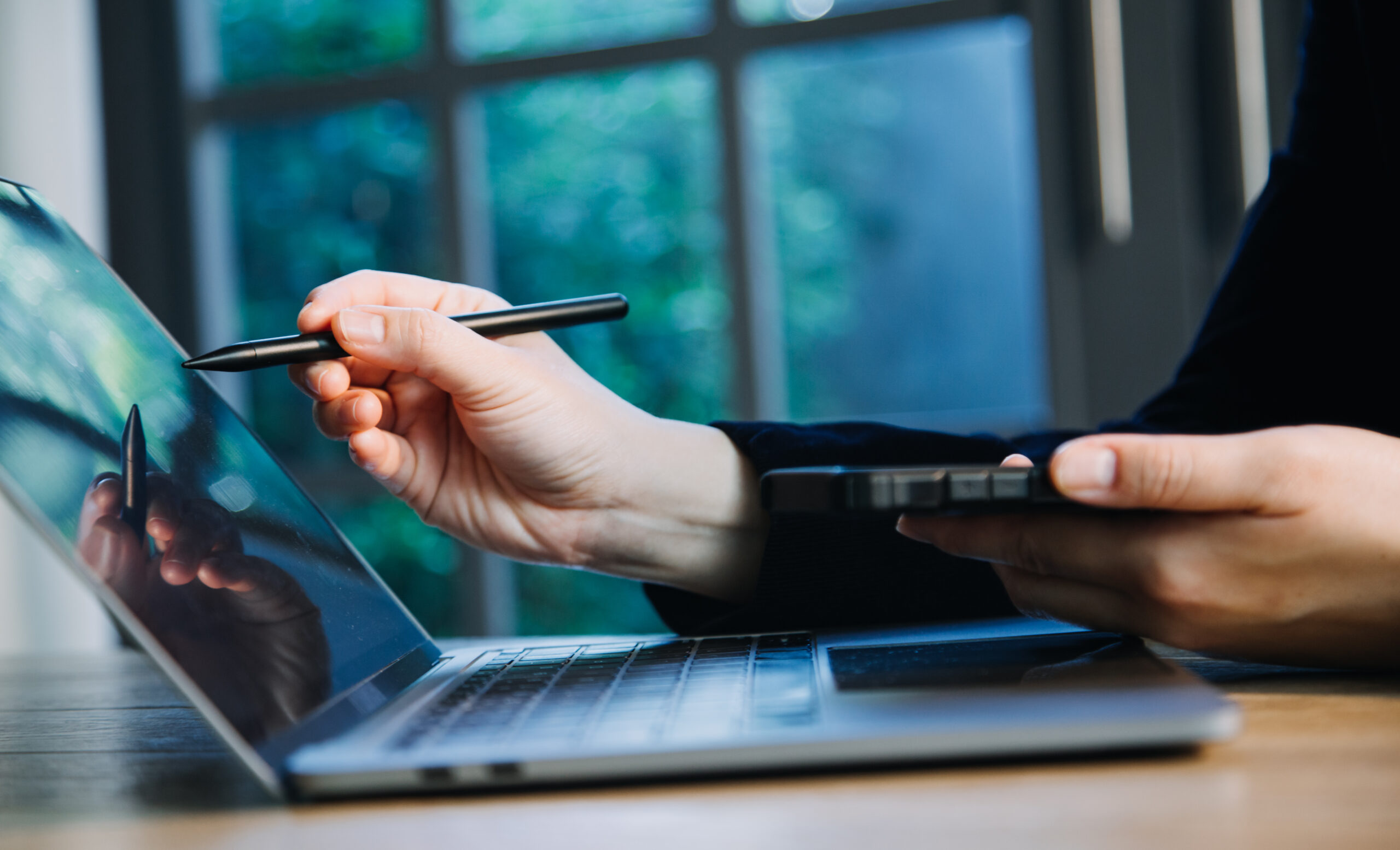 User drawing a digital signature with a stylus on a laptop while learning to create e-signature online, highlighting the convenience of electronic signatures.