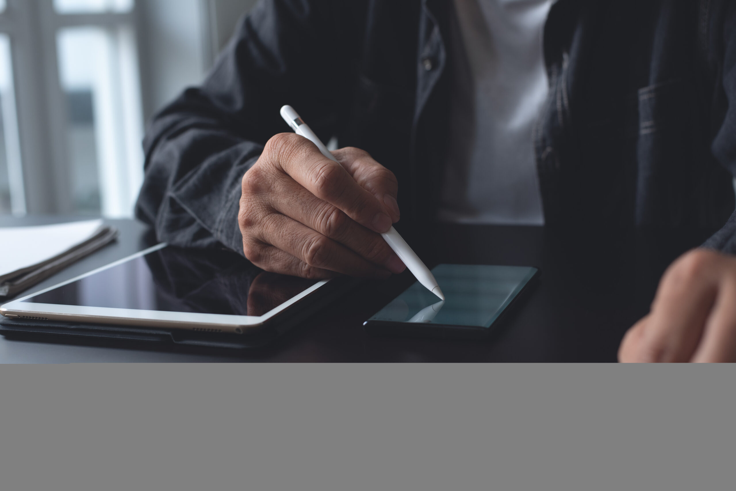 Professional reviewing documents on a tablet and laptop using an Esignature for Procurement workflow powered by a digital signature app for Procurement.