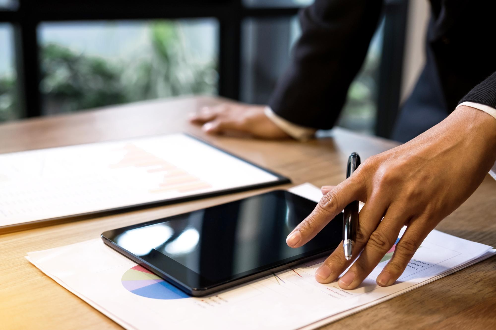 Executive using a tablet and stylus to complete sales paperwork with Electronic Signatures supported by an Esignature app for sales contracts.