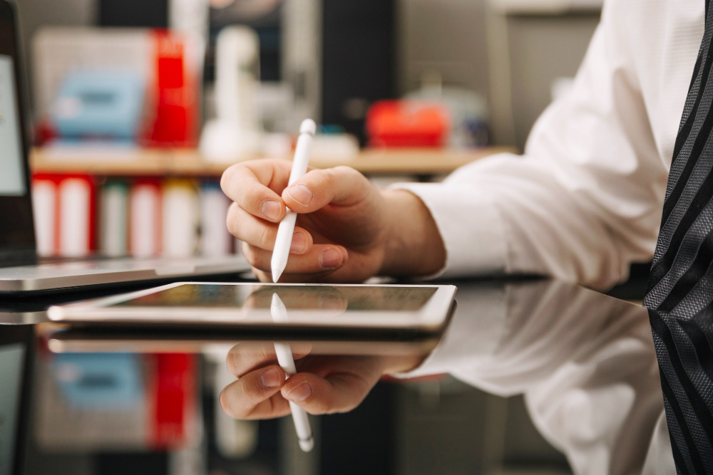 Business professional using a stylus to sign a digital document on a tablet, symbolizing the growing use of electronic signature software across industries.