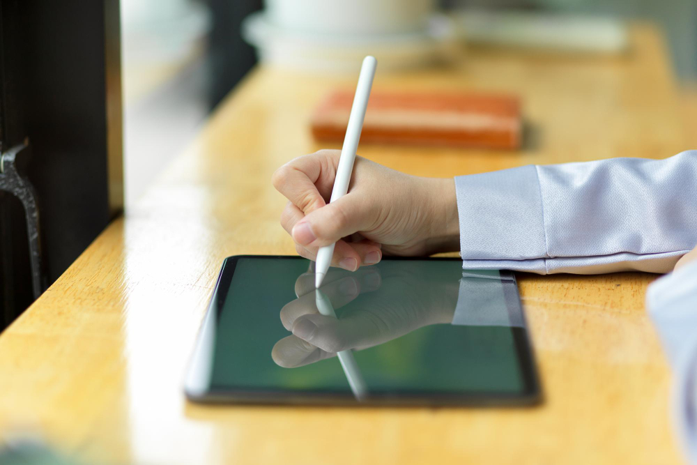 Person using a stylus to sign a document on a tablet, illustrating the adoption of electronic signature software for faster and paperless workflows.