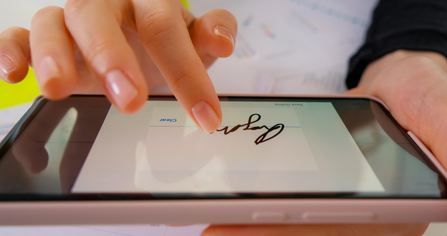 Person signing a digital document on a smartphone using electronic signature technology in 2025