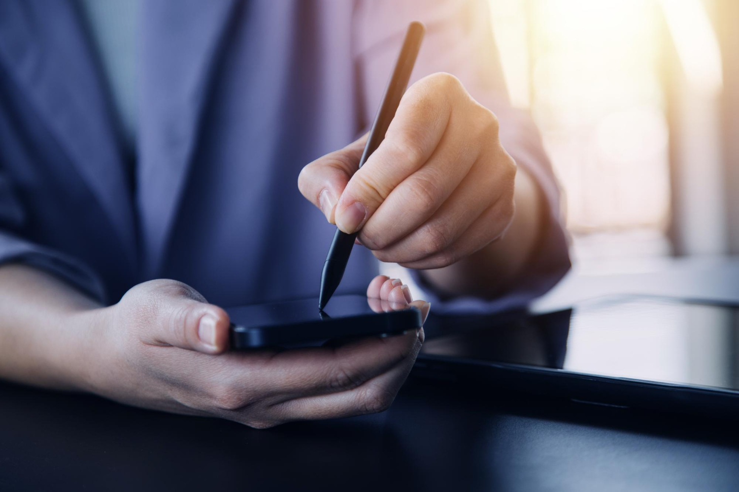 Person using a smartphone and stylus to sign digital insurance claim documents electronically for faster processing.